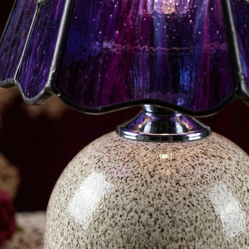 Détail macro lampe de chevet céramique vitrail violet, jonction base céramique mouchetée et abat-jour verre soufflé coloré, texture artisanale visible — Tendre Veilleuse