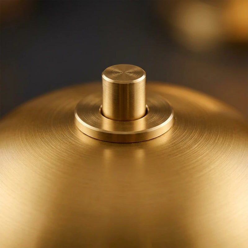 Gros plan sur la finition or aluminium brossé et le bouton
tactile du cordon supérieur de la lampe de chevet champignon
dorée sans fil — Tendre Veilleuse