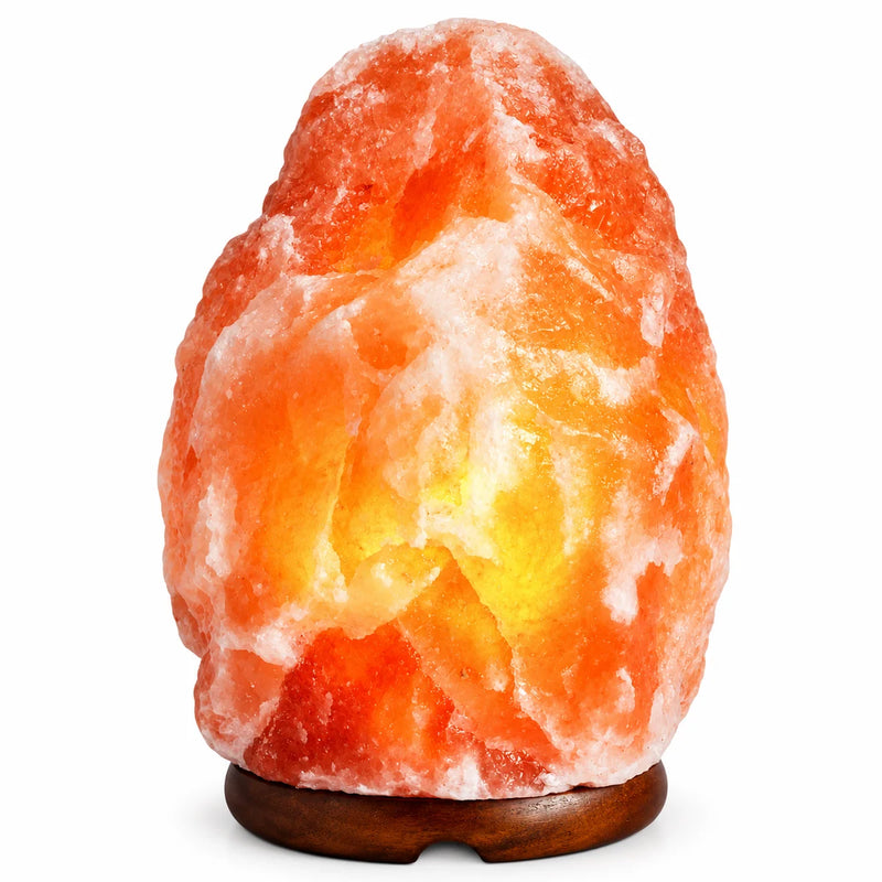 Lampe de sel de l'Himalaya naturelle 3-5 kg allumée sur son socle en bois foncé, fond blanc – Tendre Veilleuse