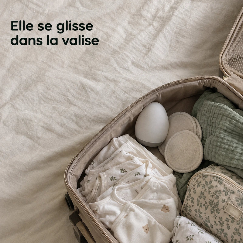 Valise de maternité ouverte avec la veilleuse oeuf éteinte et deux coussinets d'allaitement en bambou, Tendre Veilleuse