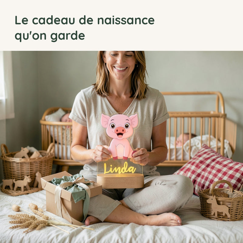 Une maman découvre la veilleuse cochon personnalisée offerte en cadeau de naissance