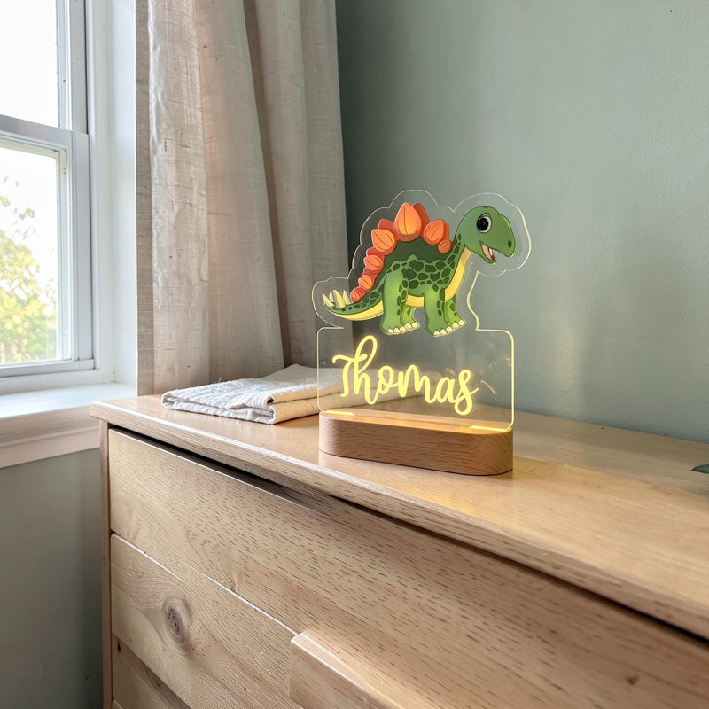 Veilleuse dinosaure personnalisée avec prénom sur une commode en chêne dans une chambre de bébé, le jour