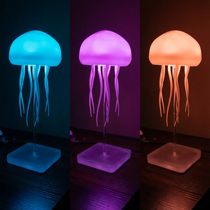Composition de trois veilleuses méduses alignées affichant différentes couleurs LED : bleu lagon, violet hypnotique et orange chaleureux, illustrant les options de personnalisation lumineuse.
