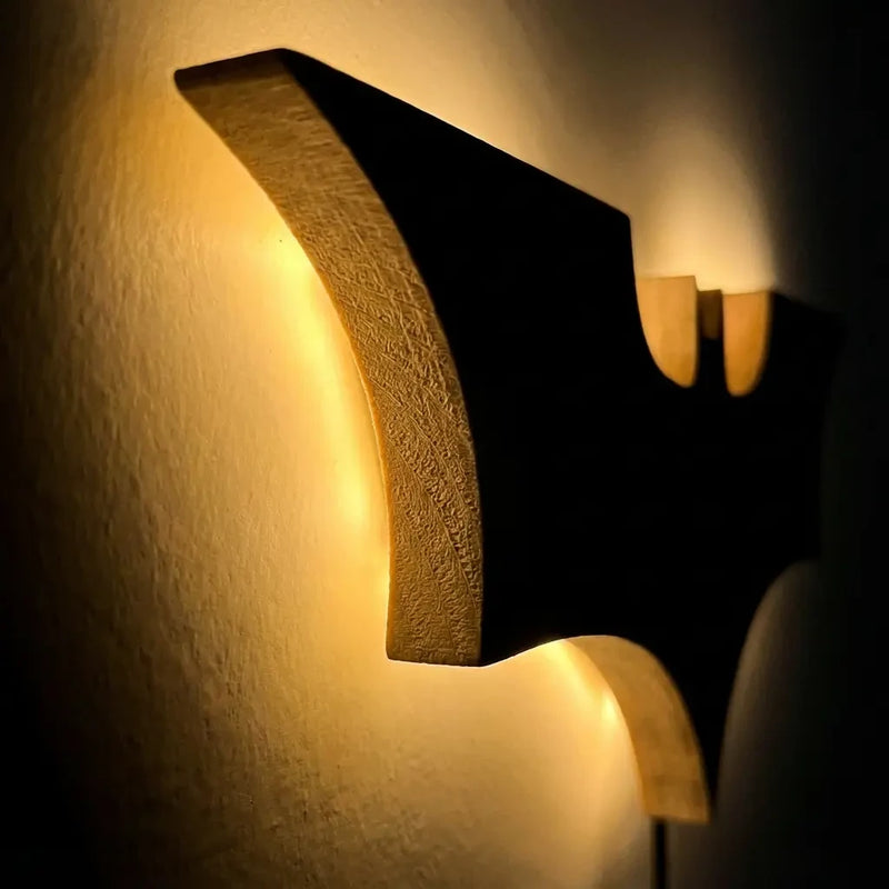 Gros plan profil texture bois de la veilleuse murale Batman avec rétroéclairage LED chaud.