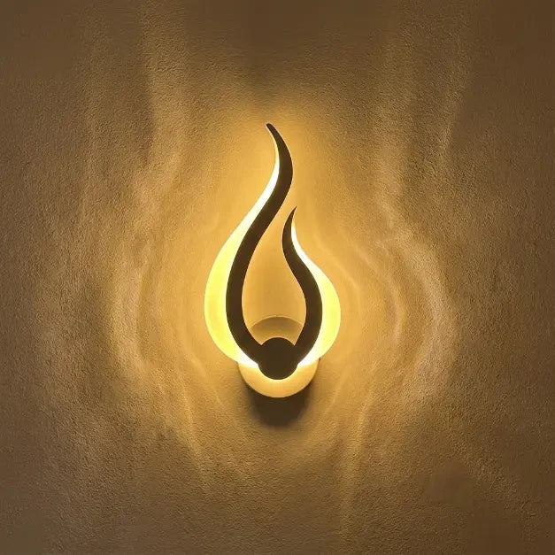 Veilleuse murale flamme allumée projetant une lueur jaune chaude sur un mur à texture artistique.