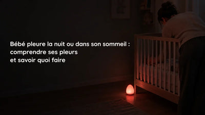 Bébé qui pleure la nuit dans son lit à barreaux, parent penché dans la pénombre près d'une veilleuse rouge, Tendre Veilleuse