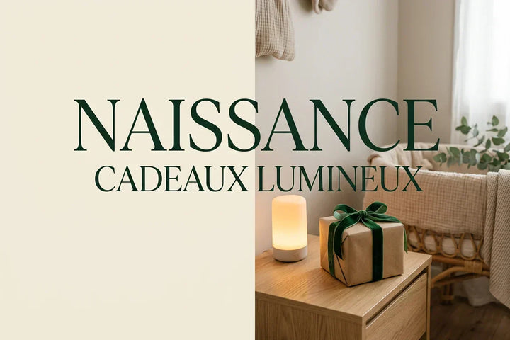Couverture guide cadeau de naissance 2026 — boîte kraft avec nœud velours vert posée sur table de chevet bois, veilleuse lumière ambrée 2200 K, chambre bébé rattan en fond flou