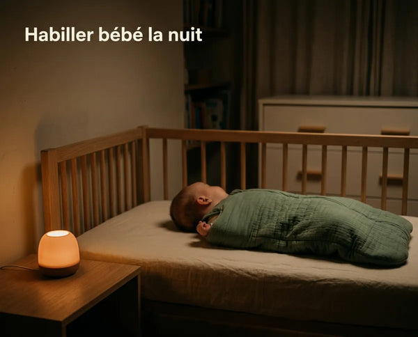 Bébé endormi sur le dos dans son lit, chambre éclairée uniquement par une veilleuse chaude de faible intensité posée sur la table de chevet