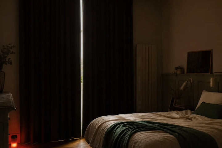 Chambre occultée en plein jour avec veilleuse lumière rouge posée au sol, protocole de sommeil diurne pour travailleur de nuit