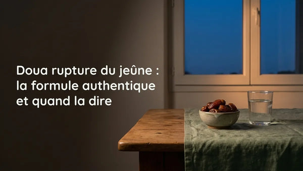 Bol de dattes fraîches et verre d'eau sur une table en bois près d'une fenêtre au crépuscule, à l'heure de l'iftar