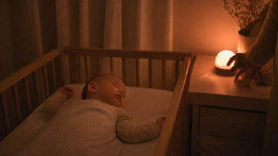 Mélatonine bébé sommeil naturel avec nourrisson endormi sous veilleuse lumière chaude qui préserve l'hormone du sommeil