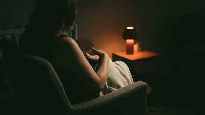 Bébé allaité endormi contre sa mère pendant une tétée de nuit éclairée en lumière rouge tamisée