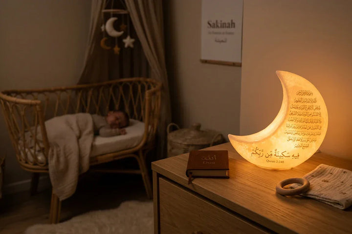 Veilleuse coranique diffusant une lumière ambrée apaisante dans une chambre de bébé la nuit.