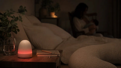 Veilleuse allaitement lumière rouge posée sur table de nuit pendant tétée nocturne, ambiance sombre apaisante, Tendre Veilleuse
