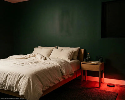 "Chambre adulte minimaliste éclairée en lumière rouge 660 nm le soir, protocole biohacking sommeil profond