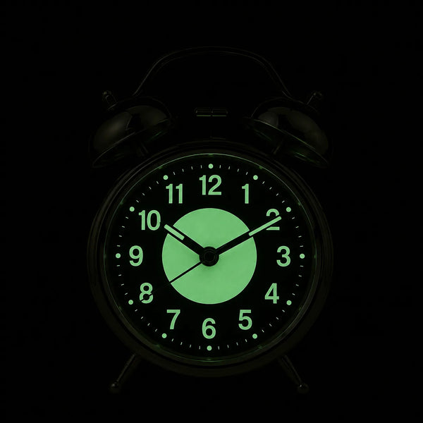 Le cadran du réveil dans l'obscurité totale, chiffres et disque central luminescents en vert pâle