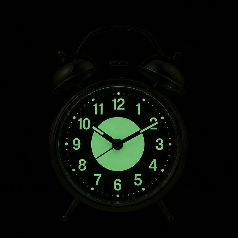 Le cadran du réveil dans l'obscurité totale, chiffres et disque central luminescents en vert pâle