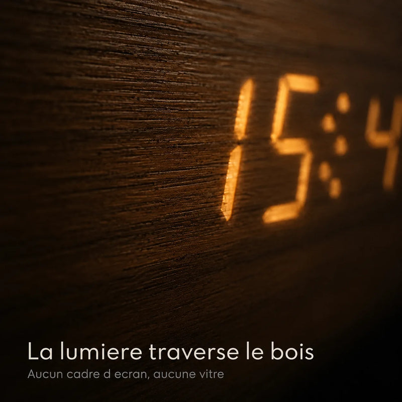 Macro en lumière rasante montrant les chiffres ambrés émergeant directement du placage bois, sans cadre ni vitre