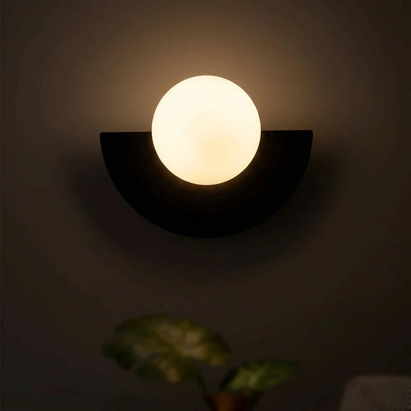 Applique murale boule G9 allumée la nuit, diffusion lumière 360 degrés douce et chaude, contraste mur taupe, ambiance chambre intime, Tendre Veilleuse