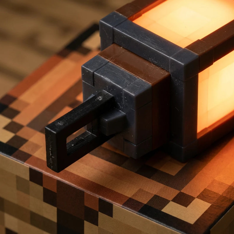 Gros plan sur les finitions en plastique robuste et la poignée de transport de la veilleuse lanterne Minecraft, garantissant sécurité et durabilité.