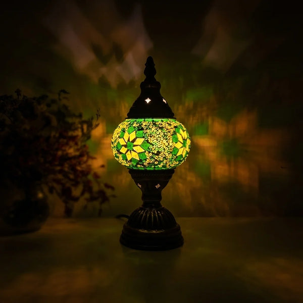 Lampe de chevet vitrail Art Déco allumée lumière ambre 2700K, reflets colorés vert et jaune projetés sur mur sombre, style lampe Tiffany artisanale — Tendre Veilleuse
