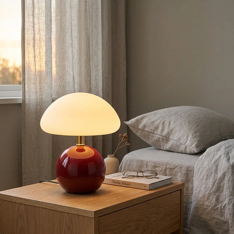Lampe de chevet céramique champignon rouge vin allumée sur table de chevet en bois clair, chambre nordique minimaliste, draps lin beige — Tendre Veilleuse