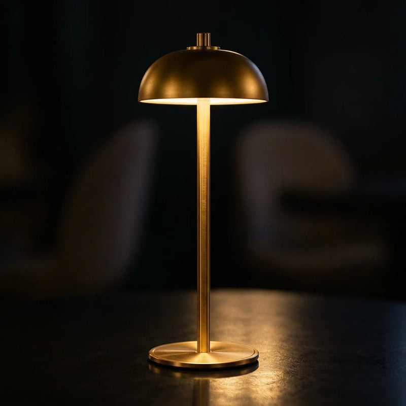 Lampe de chevet tactile champignon dorée sans fil allumée en
lumière chaude ambrée, diffusion vers le bas sur fond sombre
nocturne — Tendre Veilleuse