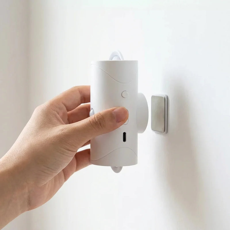 Main détachant la lampe murale sans fil rechargeable de son socle magnétique adhésif laissant apparaître le port USB-C.