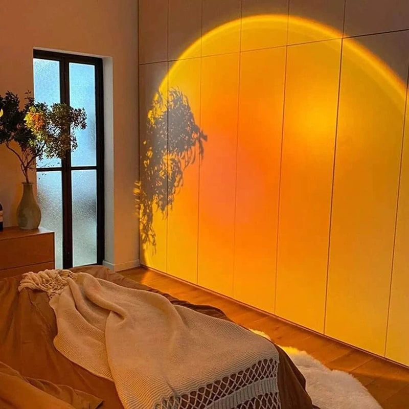 Grande projection murale effet coucher de soleil dans une chambre à coucher moderne, créant une ambiance relaxante et chaleureuse sur une armoire blanche.