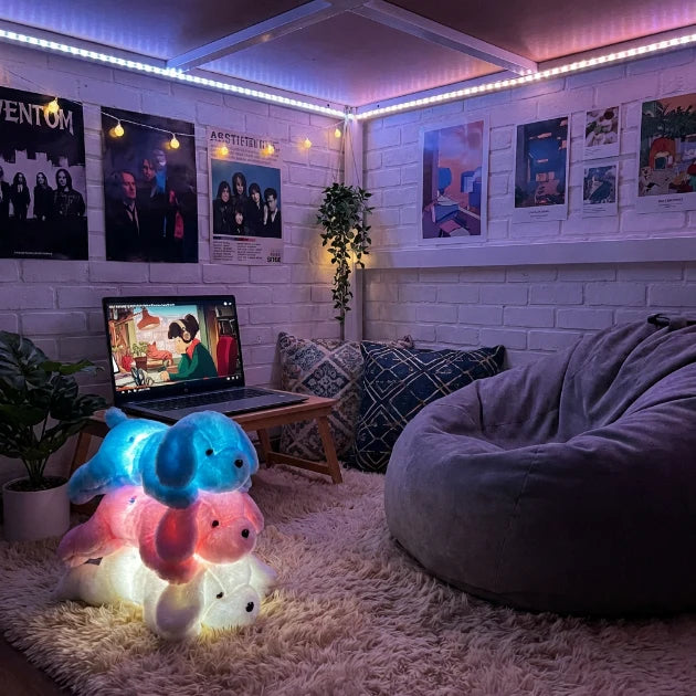 Coin détente cocooning éclairé par une pile de trois peluches chiens lumineux (bleu, rose, blanc), créant une ambiance aesthetic et kawaii idéale pour une chambre d'ado.