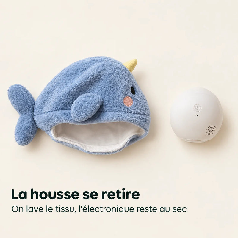 La housse en peluche de la veilleuse baleine retirée et posée à côté du module électronique blanc, illustrant le lavage