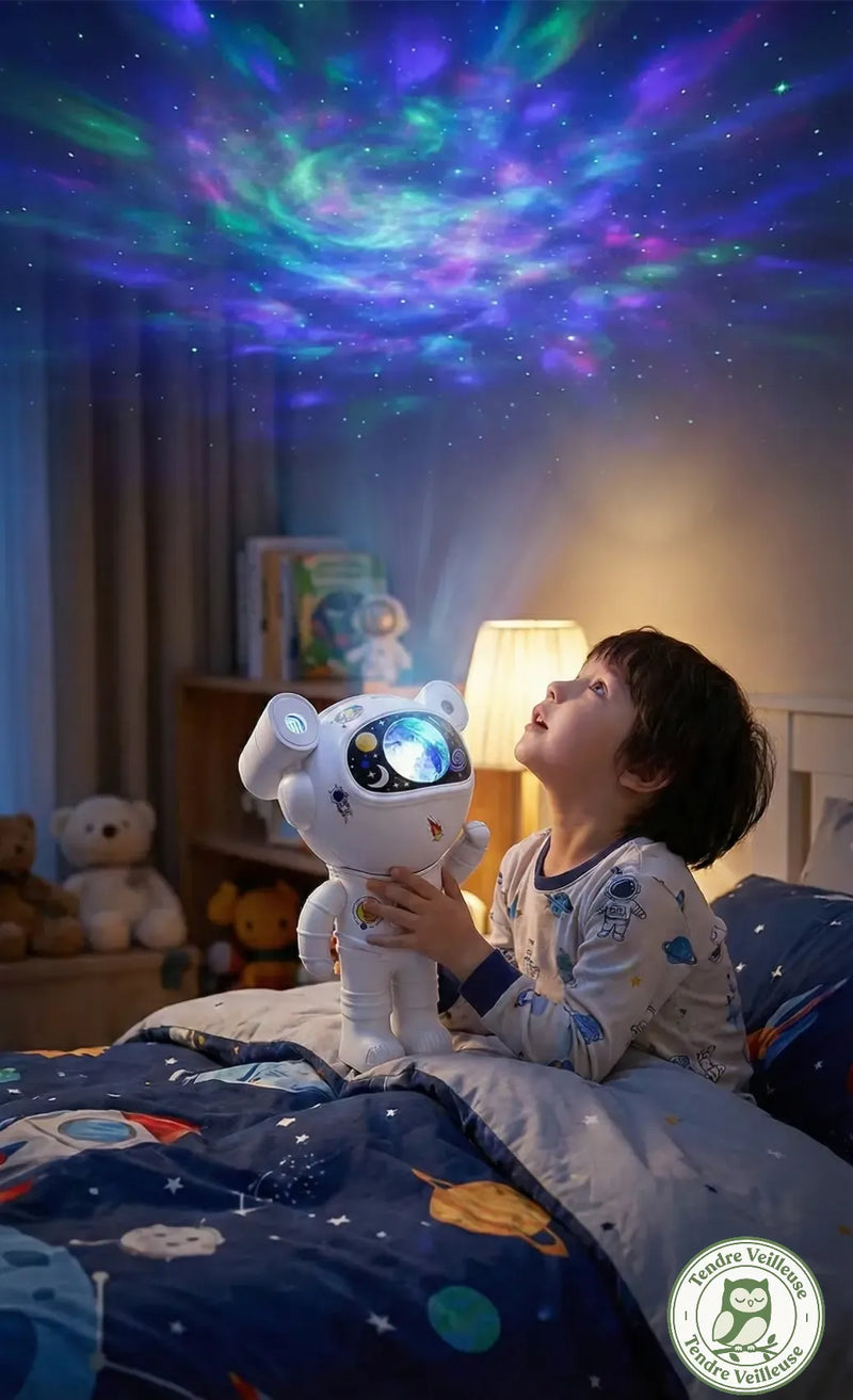 Petit garçon jouant avec la projection galaxie 360 degrés au plafond de l'astronaute Cosmo. Projecteur rotatif interactif.
