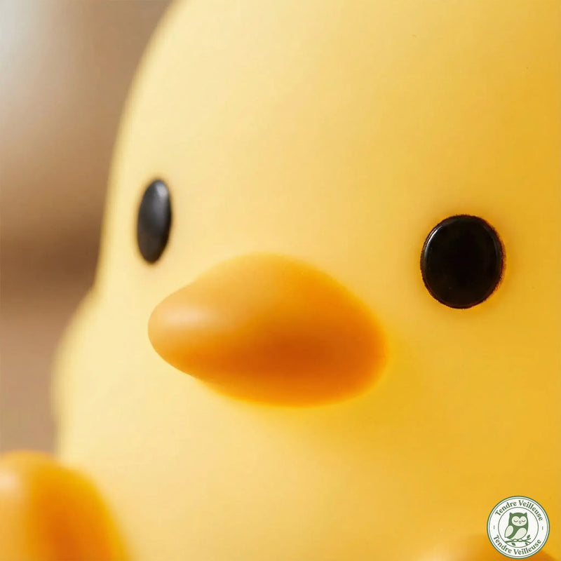 Macro détail veilleuse canard Quacko silicone alimentaire jaune, bec orange et yeux noirs, texture souple sans BPA — Tendre Veilleuse
