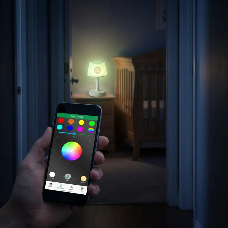 Parent contrôlant la couleur de la veilleuse coranique connectée via l'application smartphone sans entrer dans la chambre de bébé.