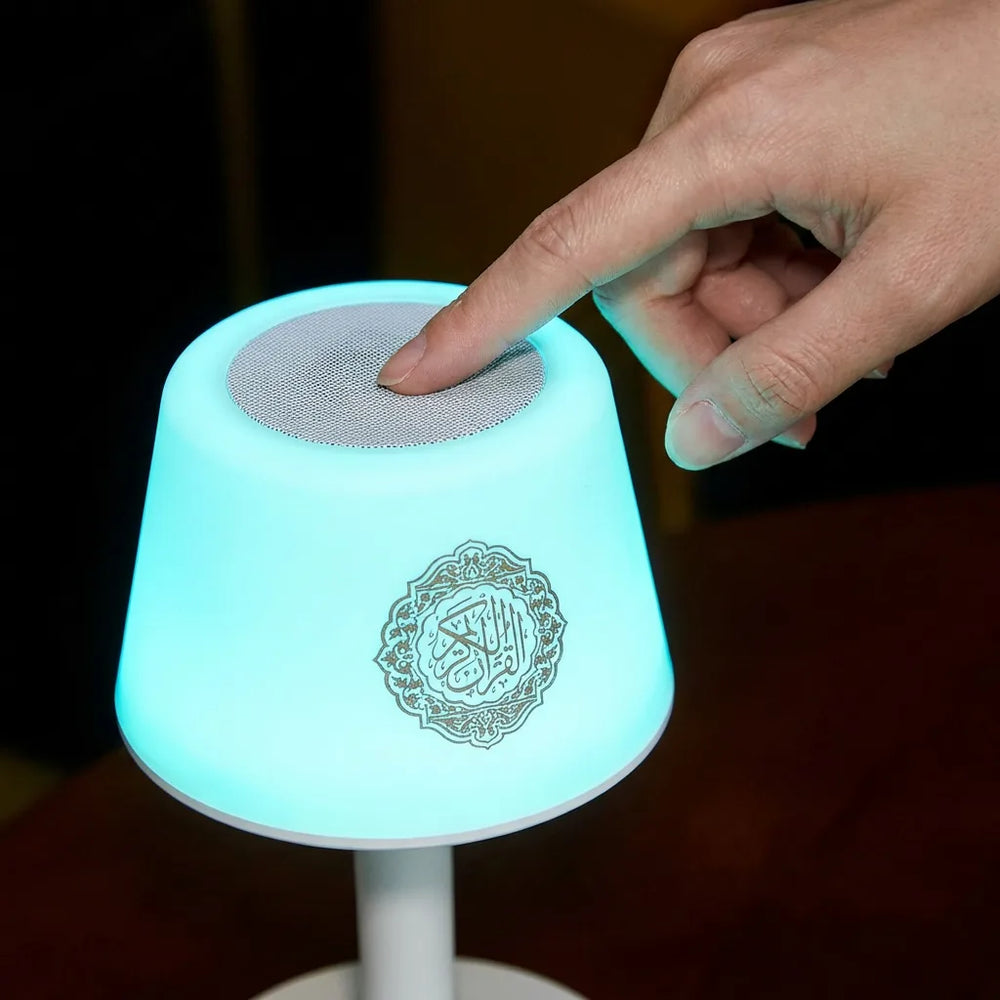 Gros plan sur la fonction tactile de l'enceinte coranique : un doigt change la couleur de la lumière bleue via le haut-parleur HD supérieur.