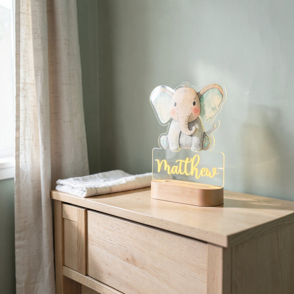 Veilleuse éléphant personnalisée avec prénom sur une commode en chêne dans une chambre de bébé, le jour