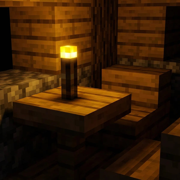 Veilleuse enfant lampe torche Minecraft allumée posée sur une table de chevet, diffusant une lumière jaune apaisante contre la peur du noir.