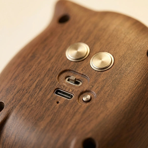 Détail macro de la base magnétique de la veilleuse hibou, texture ABS grain de bois, port USB de recharge visible — Tendre Veilleuse
