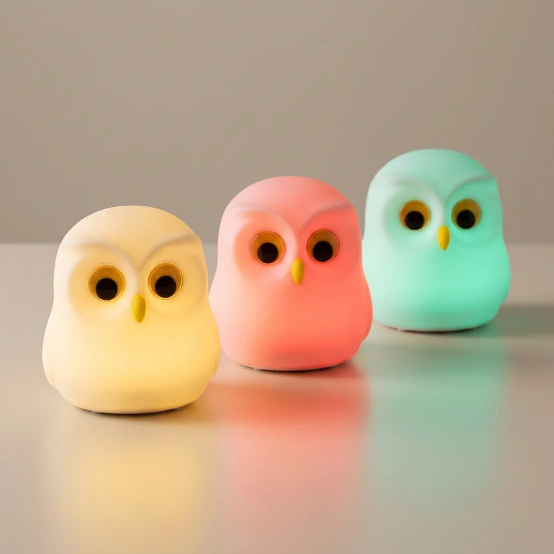 Trois veilleuses hibou silicone illuminées dans 3 modes RGB : lumière chaude crème, rose corail, vert menthe teal, posées sur surface neutre, Tendre Veilleuse