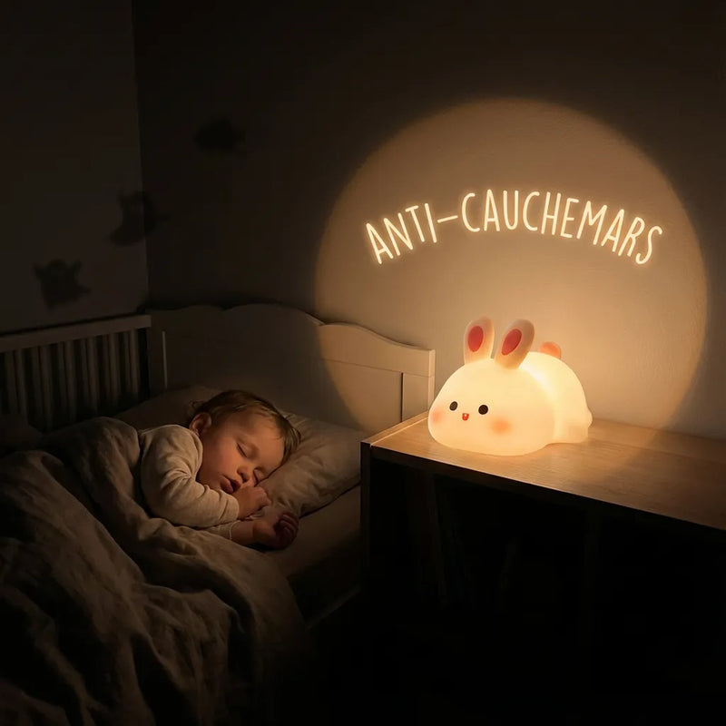 Bébé dormant paisiblement à côté de la veilleuse lapin diffusant une lumière chaude et le message lumineux 'ANTI-CAUCHEMARS' sur le mur de la chambre.
