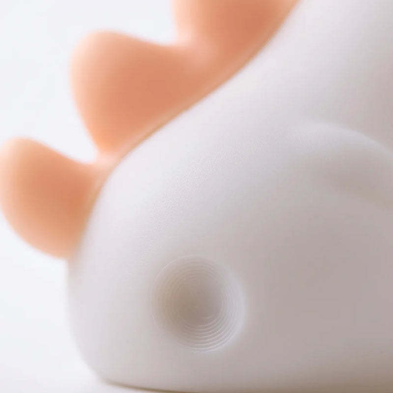 Macro sur la texture silicone souple de la Veilleuse Licorne, détail du bouton tactile à la base et de la surface mate colorée. Tendre Veilleuse