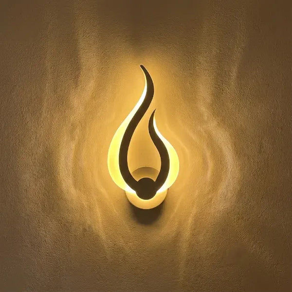 Veilleuse murale flamme allumée projetant une lueur jaune chaude sur un mur à texture artistique.