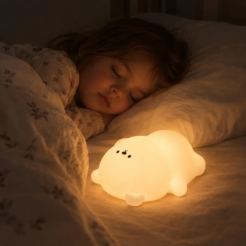 Veilleuse ours allumée en blanc chaud sur le lit d'une fillette endormie, au coucher, Tendre Veilleuse