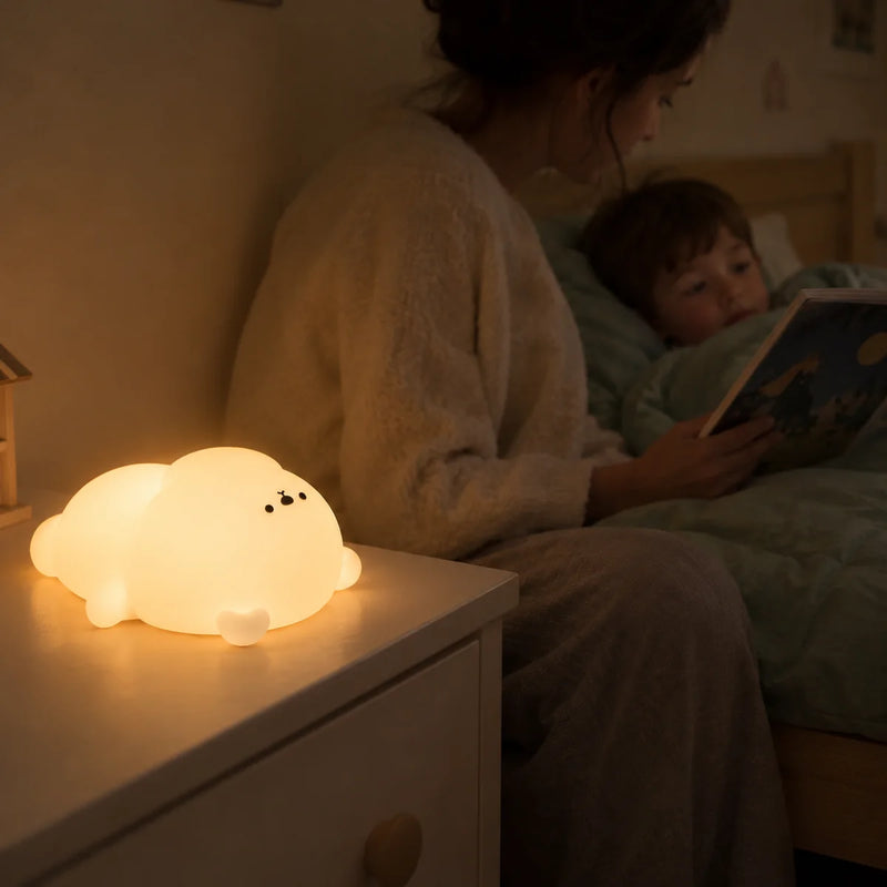 Veilleuse ours allumée sur la table de nuit pendant l'histoire du soir lue à un enfant, Tendre Veilleuse