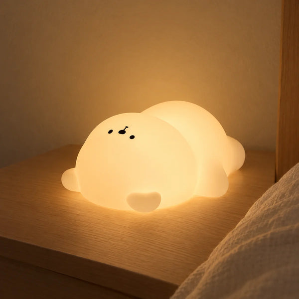 Veilleuse ours en silicone allumée en blanc chaud sur une table de chevet en bois clair, Tendre Veilleuse