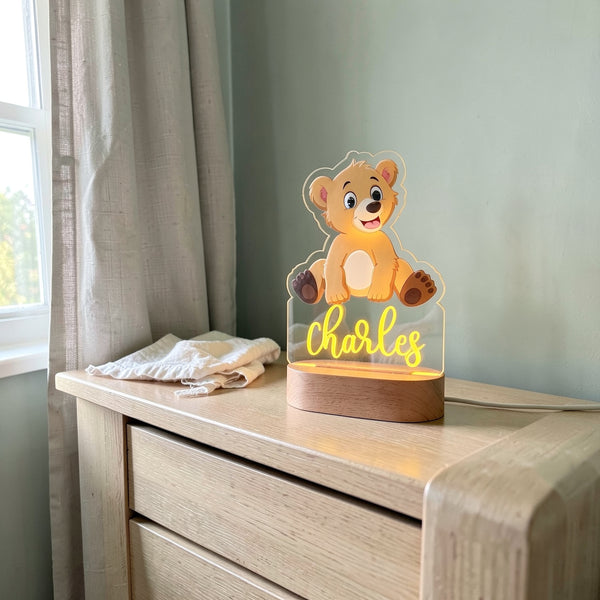 Veilleuse ourson personnalisée avec prénom sur une commode en chêne dans une chambre de bébé, le jour