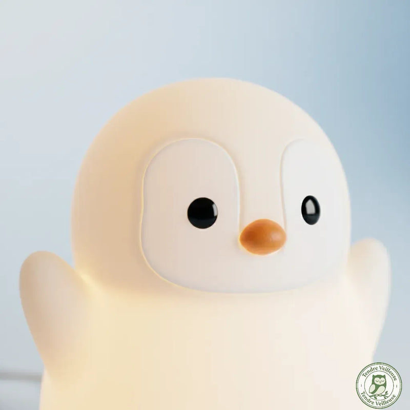 Gros plan veilleuse pingouin Pingo silicone souple sans BPA certifiée CE, détail visage bec orange et yeux ronds, Tendre Veilleuse