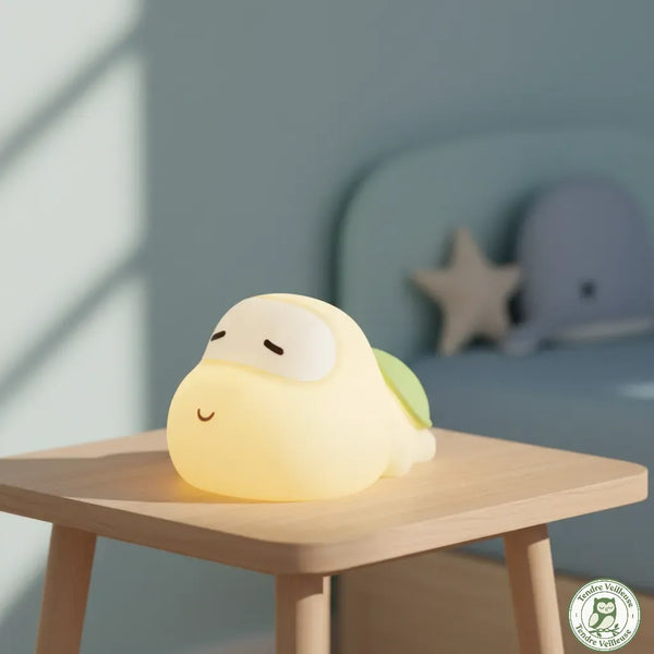 Veilleuse tortue bébé silicone Titou allumée lumière chaude sur table de nuit bois, chambre enfant bleue décor étoile — Tendre Veilleuse